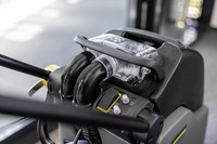 Close-up of Kärcher high-pressure cleaner controls, featuring hoses and a transparent water filter, indoors with blurred background.