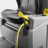 Close-up of a Kärcher hose connector attached to a grey machine with a black seat and yellow lever.