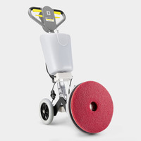 Kärcher floor polisher with a large red pad, grey handle, and wheels, set against a plain background.