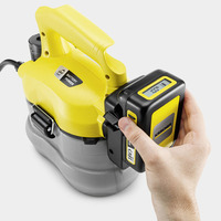 Hand inserting battery into Kärcher pressure washer with yellow handle and digital display.