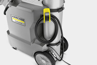 Kärcher professional cleaning machine with wheels, hose wrapped around a yellow holder, and visible connector.