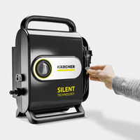 Hand plugging a cable into a Kärcher Silent Technology device, featuring a black handle and dial on a grey background.