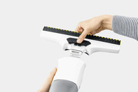 Hands assembling a Kärcher window vac, attaching the cleaning head to the main unit against a plain background.