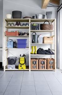 Wooden shelves in a garage with various items, including a Kärcher high-pressure cleaner, boots, baskets, and storage boxes.