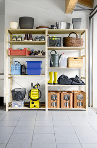 Garage shelves with assorted items including a Kärcher high-pressure cleaner, yellow boots, watering can, and storage boxes.