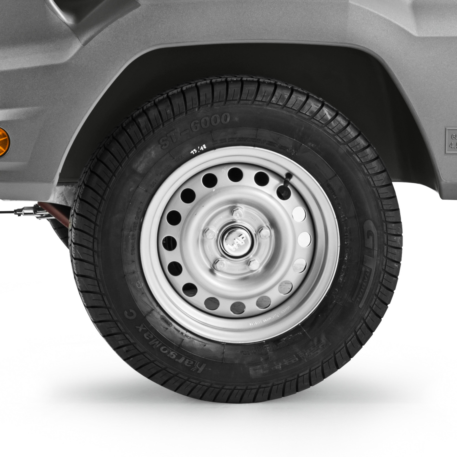 Close-up of a silver car wheel with a black tyre, showing the rim's circular holes and tyre branding "ST-6000." Close-up of a silver car wheel with a black tyre, showing the rim's circular holes and tyre branding "ST-6000."