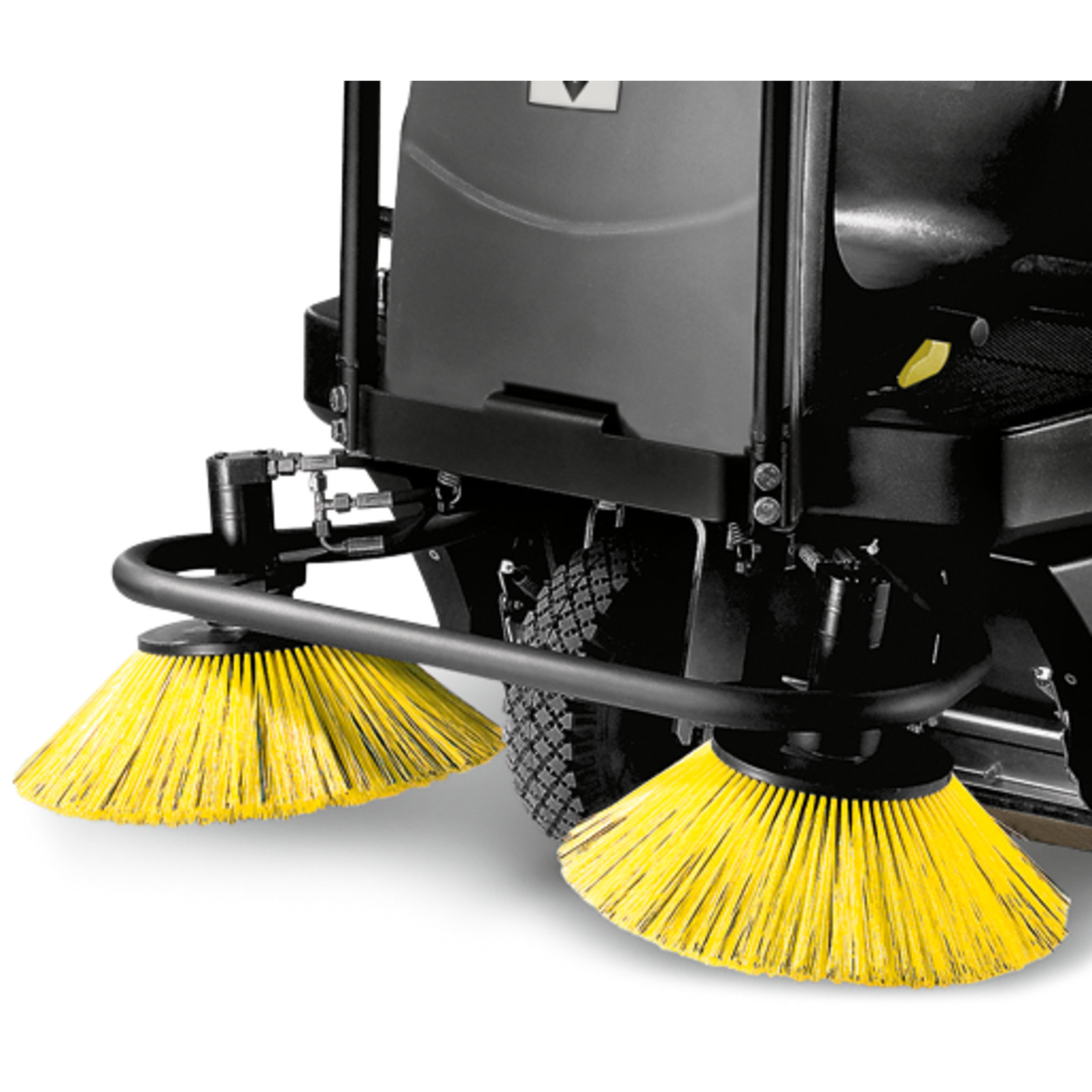 Kärcher ride-on sweeper with two yellow circular brushes and black body, close-up view. Kärcher ride-on sweeper with two yellow circular brushes and black body, close-up view.