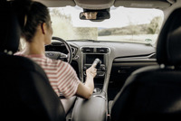 Person cleaning car dashboard with Kärcher handheld vacuum inside a parked Ford vehicle.